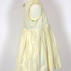 Yellow child's dress on mannequin, side view.