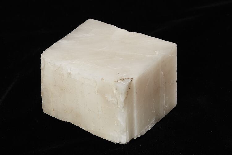 White, flat mineral in the shape of a cube.