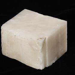 White, flat mineral in the shape of a cube.