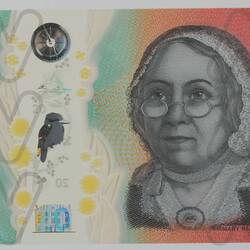 Orange polymer Australian 20 dollar note with birds and plants on left and woman on right.