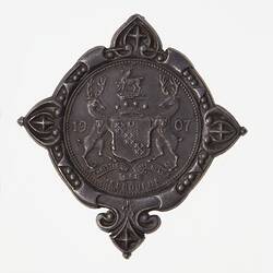 Medal with three stags surrounding a shield in centre.
