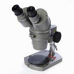 Grey optical microscope with two eye pieces.