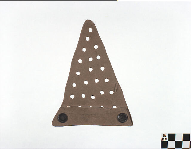 Two dimensional brown cardboard conical shaped hat with drilled holes.