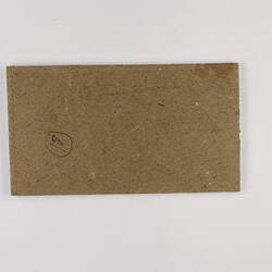 Plain back of a brown exhibition label.