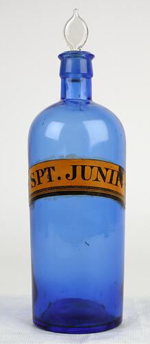 Blue glass bottle with clear glass stopper. Yellowed label with black text.