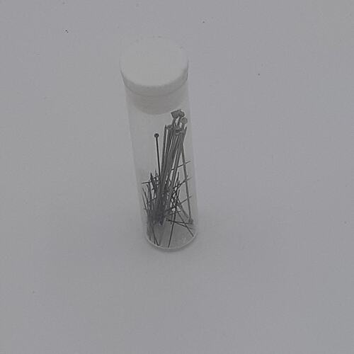 Clear tube with white lid conatining pins.