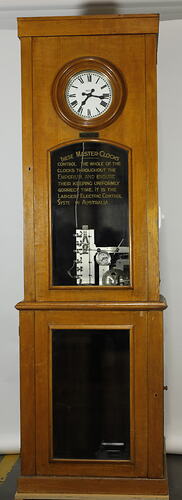 Wooden clock with white face and glass panel.