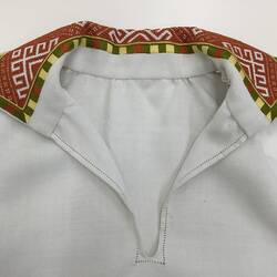 Detail of cream shirt with colourful embroidered collar.
