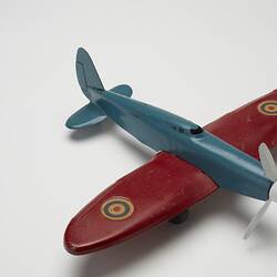 Blue and red toy aeroplane, right, front, three-quarter profile.