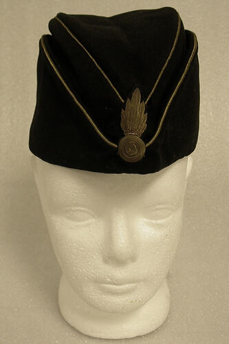 Black military uniform cap, on mannequin head, front view.