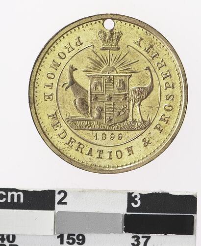 Round gold coloured medal with Australian coat of arms and text.