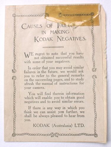 Off white leaflet with printed black text on both sides. Yellowing adhesive tape stuck to the upper edge.