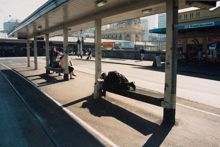 Digital Photograph - Homeless Man Sleeping on Tram Shelter, Batman Avenue, Melbourne, 1990s