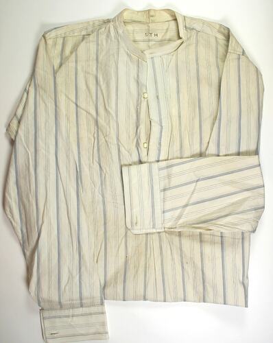 Yellow and grey striped shirt, two unbuttoned buttons.
