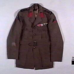 Khaki military uniform jacket, with red trim on collar and two ribbon bars above left breast pocket.