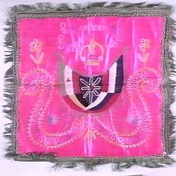 Silk square of bright pink fabric with a green fringe, design of five connected flags in centre.