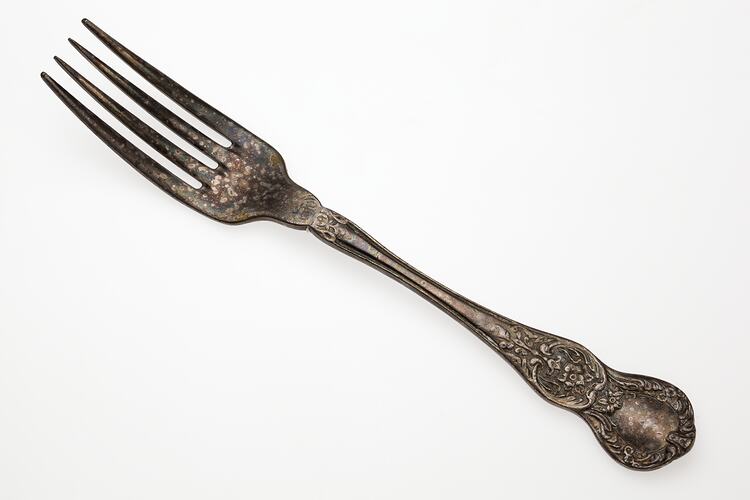 Dining fork with four prongs, imprint on handle.