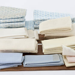 Folded fabric representing sheets and blankets.