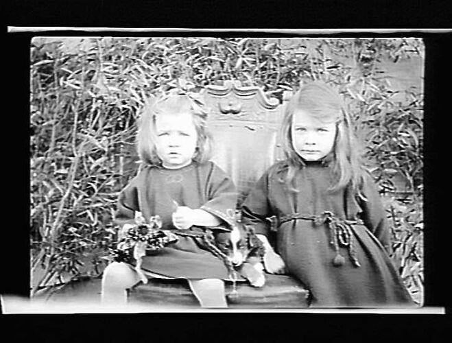 Photograph: Two girls on a chair with a puppy