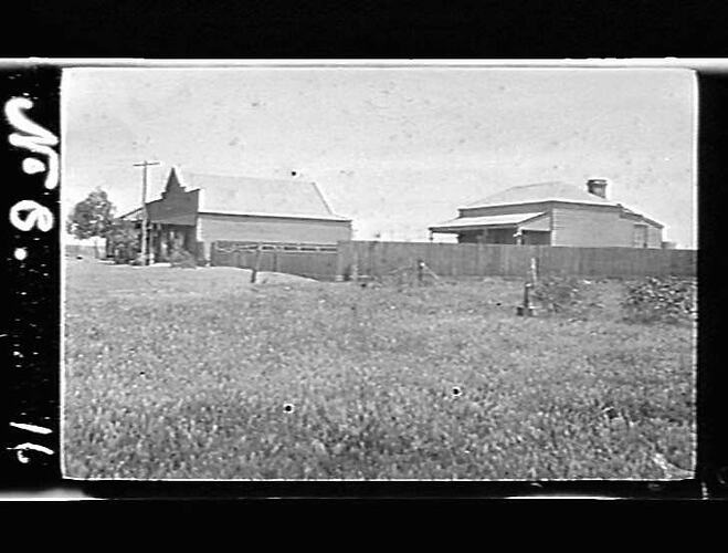 Two houses and fence in a paddock.