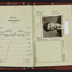 Open passport, white pages. Photo of young man. Printed and written text.