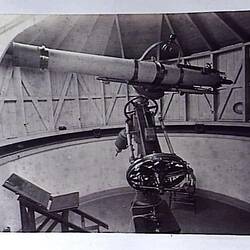 Telescope and astronomer's chair inside revolving dome.