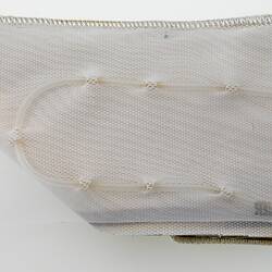 Rectangular white mesh fabric with clear tube threaded through it making C-shape.