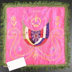 A mat with green trimmings, four flags on a pink embroidered background.