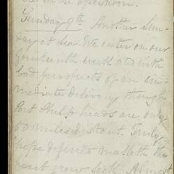 Open diary with handwritten text on discoloured worn page.