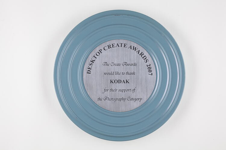 Circular silver plaque mounted on metal film canister.