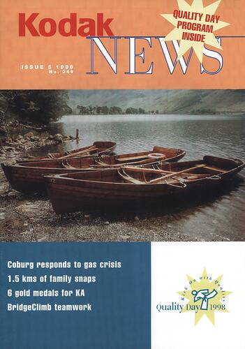 Magazine cover featuring wooden boats at shoreline.