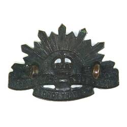 Back side of badge with rising sun motif.
