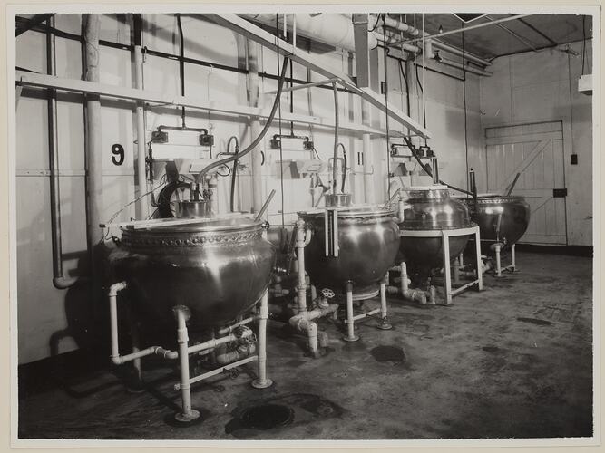 Industrial interior, dominated by four large round vats.