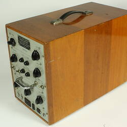 Control panel with knobs and dials. Housed in wooden box.