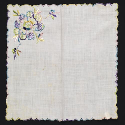 Unfolded white handkerchief with floral embroidery.