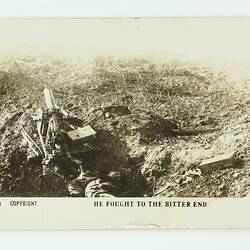Soldier lying dead on the ground next to the machine gun.