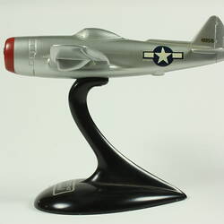 Silver model aeroplane on black stand.