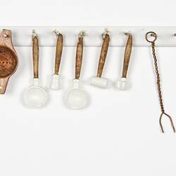 Miniature cooking utensil rack from a doll's house.