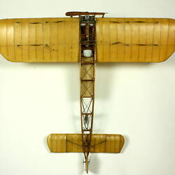 Model aeroplane with exposed wooden frame and off white panelling. Top view.