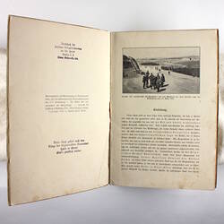 Inside pages of book showing photo of camp and text.