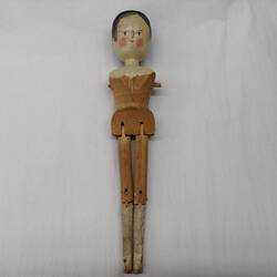 Wooden doll with painted face and articulated legs.
