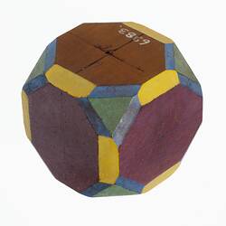 Wooden crystal model in plain timber, mauve, yellow, green and blue.