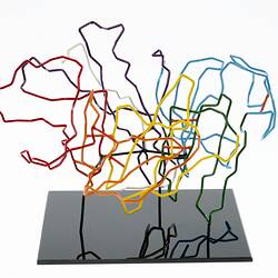 Red, orange, yellow, green, blue, purple and white coloured wires mounted on a black wooden base.