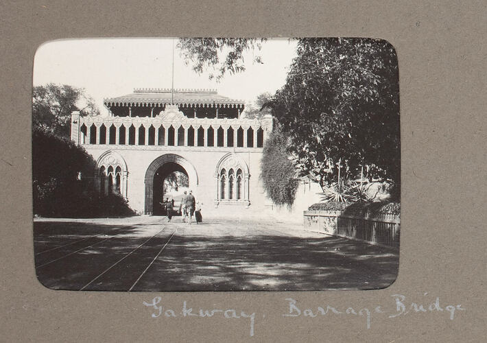 Large gateway building with arched entrance and tram tracks.