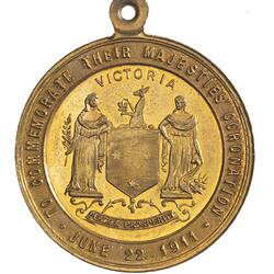 Medal with two figures standing either side of shield with kangaroo atop, text around.