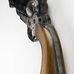 Engraved revolver with wooden handle. Detail of handle inscription.