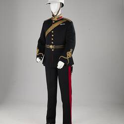 Navy officer's uniform with gold at cuff, epaulettes, belt. Brass buttons. Red/gold collar. White helmet.