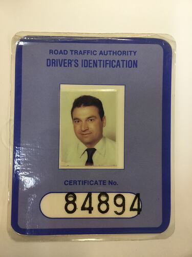 Photo identity card. Man in white shirt with dark tie. Blue frame, black text.