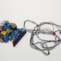 Grey cables attached to black, blue, red, yellow and grey plastic component.