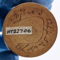 Base of round wooden cylindrical box. Has handwritten text.